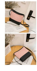 Détails de la couture matelassée rose et base en cuir noir sur un sac seau chic