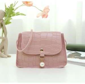 Détail du petit sac rose à motif pierre avec pendentif perle et fermoir doré chic
