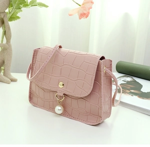 Détail du mini sac rose à motif pierre avec pendentif perle et fermoir doré