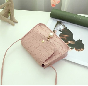 Détail du petit sac rose en cuir synthétique avec texture pierre et perle