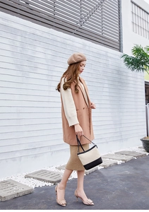 Photo de rue d'une femme portant un gilet kaki et un sac à main bicolore tendance