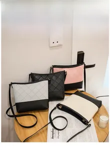 Détail de sacs seau bicolores avec motif matelassé disposés sur un tabouret