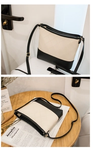 Détail d'un sac seau bicolore noir et blanc avec d'élégantes surpiqûres en cuir matelassé