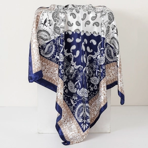 Blue and white paisley satin silk scarf draped over a cube base in 90cm size