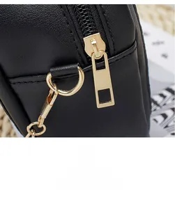 Detailed macro shot of smooth gold-tone zipper and hardware on black quilted leather bag