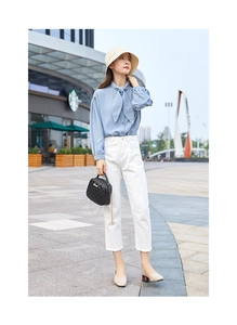 Chic urban outfit featuring light blue bow-tie shirt, white jeans and black quilted handbag