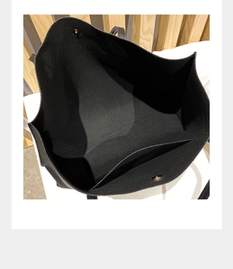 Interior view of black litchi pattern tote bag showing magnetic buckle and inner pocket