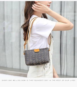 Close-up of printed crossbody bag featuring yellow flap closure and gold metal hardware