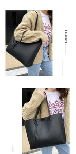 Detail of black lychee grain tote bag showing fringe tassel and gold magnetic buckle