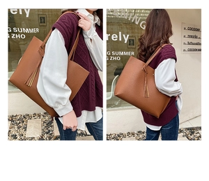 Brown lychee pattern tote bag with tassel detail shown on model in street setting