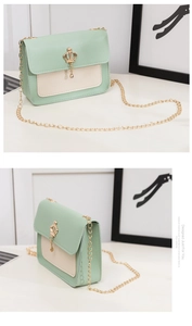 Détail du sac bandoulière vert menthe et beige avec boucle couronne dorée et chaîne