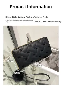 Detail of black women long wallet with heart pattern, gold zipper and fluffy keychain