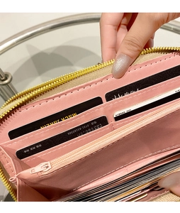 Macro shot of pink long wallet interior with card slots and a golden zipper compartment