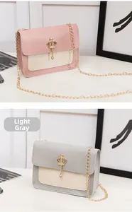 Détail de mini sacs bandoulière avec breloques couronne dorée et chaînes en deux couleurs