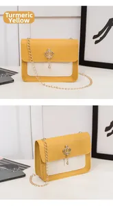 Détail du petit sac bandoulière moutarde et blanc avec breloque couronne et chaîne