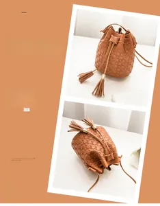 Detail view of tan bucket bag showing embossed texture, tassels and gunmetal hardware