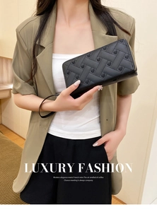 Detail of black woven leather wallet with heart embroidery and golden zipper wristlet
