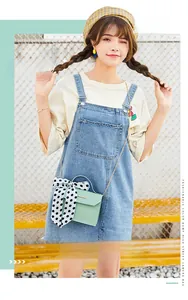 Detail of mint green crossbody bag featuring a polka dot scarf handle and slim chain
