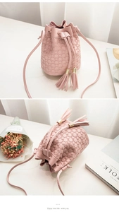 Detail of pink bucket bag with embossed circular texture, drawstring and tassel accents