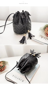 Detail of black drawstring bucket bag with geometric texture and elegant long tassels
