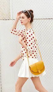 Model wearing a bright yellow minimalist saddle bag with a smooth leather finish