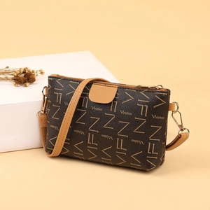 Brown vintage leather crossbody bag with VIFN monogram and gold hardware on warm backdrop