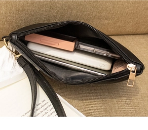 Detail of black envelope clutch bag showing large capacity for phone and makeup