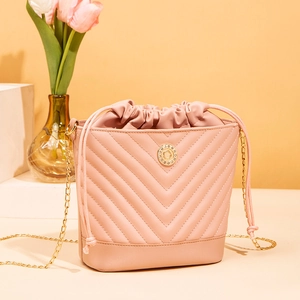 Detail of pink bucket bag featuring V-shaped quilting and rhinestone metal hardware