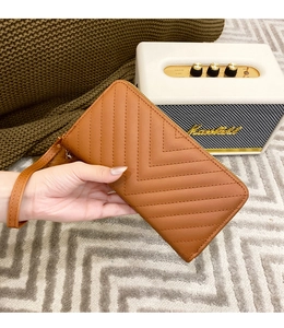 Close-up of brown long wallet with V-shaped quilted texture and detachable wrist strap