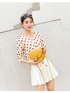 Yellow saddle bag cross-body style shown with model in a fresh summer outfit context