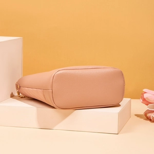 Detail view of pink bucket bag showing quilted leather texture and gold chain link