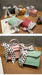 Detail of square crossbody bags with polka dot scarves and gold chain straps
