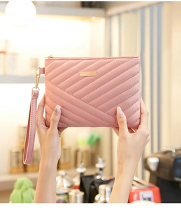 Detail view of pink quilted handbag featuring diagonal stitching and golden zipper closure