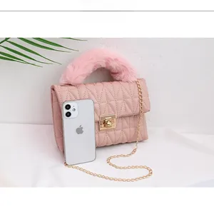 Detailed view of pink quilted handbag with plush handle and gold chain strap