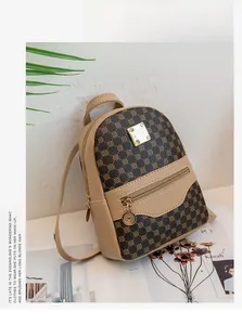 Detail of a vintage mini backpack with monogram print, metal logo, and gold zipper