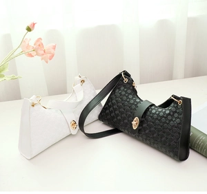 Λεπτομέρεια από ανάγλυφες τσάντες με χρυσό κούμπωμα και σχέδιο σε σχήμα μισοφέγγαρου