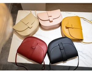 Top view of mini saddle bags in five matte colors on white marble background