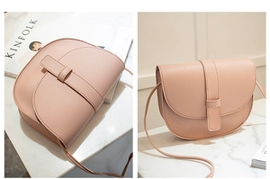 Detail view of a pink PU leather saddle bag with flap closure on marble background