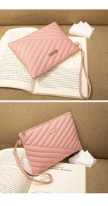 Close-up of pink quilted PU leather envelope clutch bag with gold zipper and wristlet