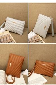 Detailed view of quilted faux leather wristlet clutch with gold accent in white and brown