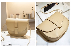Detail of a beige saddle bag on a marble surface showing leather texture and strap