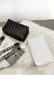 Detail of quilted camera bags in black and white with patterned wide woven straps