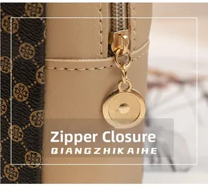 Detailed macro view of the premium golden zipper and printed leather on women's bag