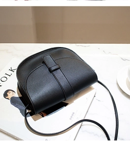 Detail of black pebbled leather saddle bag with belt buckle on Kinfolk magazine