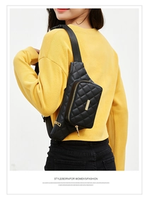 Close-up of quilted waist bag featuring gold zippers and adjustable nylon strap