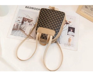 Mini crossbody backpack with geometric circle patterns and a decorative ribbon on a magazine