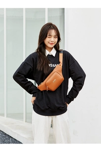 Brown quilted leather waist bag with gold zipper and durable strap worn by a model
