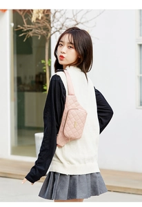 Close-up of light pink quilted fanny pack with gold metal plate and adjustable strap
