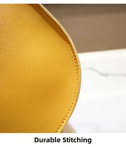 Macro detail of sturdy stitching and lychee texture on yellow saddle bag edge