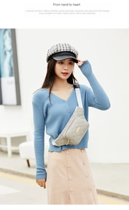 Detailed view of grey quilted waist bag with golden metal bar and wide fabric strap